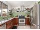 Well-equipped kitchen featuring stainless steel appliances, wood cabinets, and stylish green tile backsplash at 1018 E Tonto Ln, Phoenix, AZ 85024