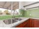 Close-up of the kitchen area showcasing a stainless steel sink, granite countertops, and bright tile backsplash at 1018 E Tonto Ln, Phoenix, AZ 85024