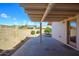 A covered patio with a brick wall and desert landscaping in the backyard at 10228 W Andover Ave, Sun City, AZ 85351