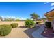 Private backyard with desert landscaping and covered patio at 10228 W Andover Ave, Sun City, AZ 85351