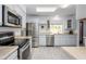 Bright kitchen featuring stainless steel appliances, light gray cabinetry, and a skylight at 10228 W Andover Ave, Sun City, AZ 85351