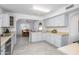 Spacious kitchen with gray cabinets, ample countertop space, and views to the dining room at 10228 W Andover Ave, Sun City, AZ 85351