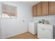 Functional laundry room with washer, dryer, storage cabinets, and natural light at 10228 W Andover Ave, Sun City, AZ 85351