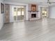 Spacious living room featuring light wood flooring, a fireplace, and sliding glass doors to the backyard at 10228 W Andover Ave, Sun City, AZ 85351