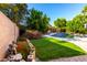 Serene backyard features green turf and lovely landscaping, creating a peaceful and private retreat at 10452 E Florian Ave, Mesa, AZ 85208