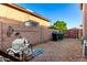 Practical backyard area with gravel, brick wall, and utility connections providing functionality and space for outdoor activities at 10452 E Florian Ave, Mesa, AZ 85208