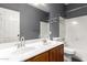 Bathroom features a double sink vanity with decorative mirrors and a shower-tub combo at 10452 E Florian Ave, Mesa, AZ 85208