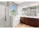 Bright bathroom showcasing double sink vanity, soaking tub, and glass enclosed shower at 10452 E Florian Ave, Mesa, AZ 85208
