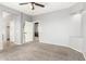 Neutral bedroom boasts carpeted flooring and a ceiling fan, adjacent to a walk-in closet at 10452 E Florian Ave, Mesa, AZ 85208