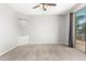 This is a light-filled bedroom with modern ceiling fan and sliding glass door access to outdoor balcony at 10452 E Florian Ave, Mesa, AZ 85208