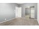 Neutral bedroom boasts carpeted floors, access to ensuite bath and a mirrored sliding-door closet at 10452 E Florian Ave, Mesa, AZ 85208