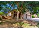 Two-story home featuring a two-car garage, neutral colors, and mature shade tree at 10452 E Florian Ave, Mesa, AZ 85208
