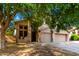 Two-story home featuring a two-car garage, neutral colors, and mature shade tree at 10452 E Florian Ave, Mesa, AZ 85208