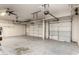 Large garage space with multiple garage doors, ceiling fan, and ample room for storage and parking vehicles at 10452 E Florian Ave, Mesa, AZ 85208