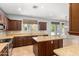 Bright kitchen with island, stone countertops, and view into adjacent living space at 10452 E Florian Ave, Mesa, AZ 85208