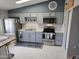 Well-lit kitchen features gray cabinetry, modern stainless steel appliances, and a stylish backsplash at 10624 W Oakmont Dr, Sun City, AZ 85351