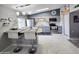 Well-lit kitchen with grey cabinetry, stainless steel appliances, and a central island with barstool seating at 10624 W Oakmont Dr, Sun City, AZ 85351