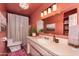 Bathroom with coral walls, a white vanity, white shower curtain and modern lighting at 1109 E 8Th St, Mesa, AZ 85203