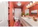 Stylish bathroom featuring coral walls, a white vanity, and a starburst light fixture at 1109 E 8Th St, Mesa, AZ 85203