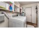 Functional laundry room with white washer and dryer, storage shelves, and a utility sink at 1109 E 8Th St, Mesa, AZ 85203