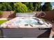 Inviting hot tub with bubbling water, set against a backdrop of lush greenery and a privacy wall at 11207 N 165Th Ave, Surprise, AZ 85388