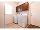 Laundry room featuring a washer and dryer, storage cabinets, and a utility sink at 11207 N 165Th Ave, Surprise, AZ 85388