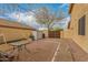 Exterior shot of a home's backyard with a concrete patio, gravel landscaping, an exterior storage shed, and mature trees at 1165 E Erie St, Gilbert, AZ 85295