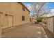 Backyard featuring a concrete patio, gravel landscaping, a neutral colored two story home, and mature trees at 1165 E Erie St, Gilbert, AZ 85295