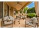 Covered patio with comfortable seating, ceiling fan, and outdoor curtains providing a relaxing outdoor living space at 1165 E Erie St, Gilbert, AZ 85295