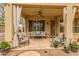 View of the cozy covered patio complete with comfortable seating, a ceiling fan, and decorative curtains at 1165 E Erie St, Gilbert, AZ 85295