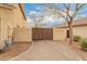 Exterior shot of a home showcasing a concrete driveway leading up to a wood driveway gate and the side of the house at 1165 E Erie St, Gilbert, AZ 85295