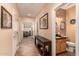 Hallway with artwork and console table leading to the office and bathroom at 1165 E Erie St, Gilbert, AZ 85295