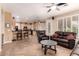 Open-concept living room featuring tile floors, a ceiling fan, and large windows with plantation shutters at 1165 E Erie St, Gilbert, AZ 85295