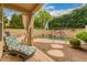 Covered patio with lounge chair overlooking the fenced in pool with waterfall feature at 1165 E Erie St, Gilbert, AZ 85295