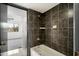 Bathroom tub with black tile surround, including shower and soap fixtures at 122 S Hardy Dr # 6, Tempe, AZ 85281