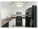 Functional kitchen featuring a black range, black refrigerator, and tile flooring at 122 S Hardy Dr # 6, Tempe, AZ 85281