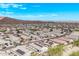 Expansive aerial view of a residential community nestled against a mountain range under a clear blue sky at 13529 W Remuda Dr, Peoria, AZ 85383