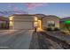 Charming single-story home with a two-car garage, desert landscaping and inviting curb appeal at dusk at 13529 W Remuda Dr, Peoria, AZ 85383