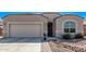 Attractive home with desert landscaping, a two-car garage, and an arched window at 13529 W Remuda Dr, Peoria, AZ 85383