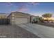 Charming single-story home with a two-car garage and inviting curb appeal during dusk at 13529 W Remuda Dr, Peoria, AZ 85383