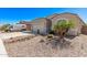 Front exterior of the home with low maintenance desert landscaping, an attached garage, and a wide driveway at 13529 W Remuda Dr, Peoria, AZ 85383