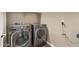 Side-by-side laundry room with gray, front-loading washer and dryer units at 13529 W Remuda Dr, Peoria, AZ 85383