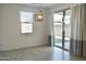 Bright dining area boasts a modern light fixture, window, and sliding glass door with neutral colored drapes at 14132 W Valentine St, Surprise, AZ 85379