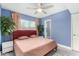 Well-lit bedroom with a queen-sized bed, neutral bedding, ceiling fan, and blue accent wall at 1435 W 6Th St, Mesa, AZ 85201