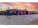 Single-story home featuring gravel landscaping, striking blue exterior, and pink garage door at 1435 W 6Th St, Mesa, AZ 85201