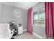 Well-lit office with gray walls, a work space, and a bright window with pink curtains at 1435 W 6Th St, Mesa, AZ 85201