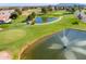 Aerial view of a golf course community featuring a pond with a fountain and scenic views at 1538 E Peach Tree Dr, Chandler, AZ 85249