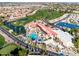 Aerial view showcasing a resort with a pool, palm trees, tennis courts, and lush landscaping at 1538 E Peach Tree Dr, Chandler, AZ 85249