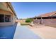 Backyard with neutral tile, a small grassy patch, and a stone-bordered garden at 1538 E Peach Tree Dr, Chandler, AZ 85249