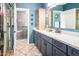 Stylish bathroom with a blue vanity, a spacious shower, and granite countertops at 1538 E Peach Tree Dr, Chandler, AZ 85249